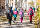 children go to school on the sidewalk with a fun company.